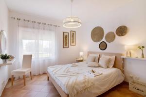 a white bedroom with a bed and a window at Mare Cheia in Santa Luzia +26 photos