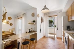 a kitchen with white walls and a counter with stools at Mare Cheia in Santa Luzia