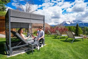 a group of people sitting in chairs in the grass at Chalet Schlossberg Latemar in Nova Ponente