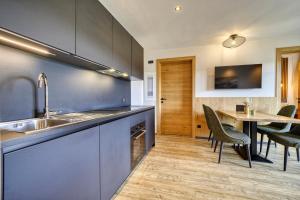 a kitchen with a sink and a table with chairs at Chalet Schlossberg Latemar in Nova Ponente