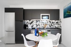 a kitchen with a white table and white chairs at Coral 5 in La Santa