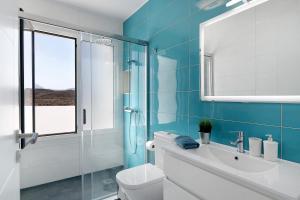 a bathroom with a toilet and a glass shower at Coral 5 in La Santa +14 photos