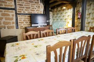 a dining room with a table and a television at La Platería I in Mambrilla de Castrejón