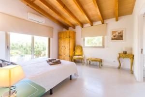 a bedroom with a bed and a large window at Son Perot in Maria de la Salut