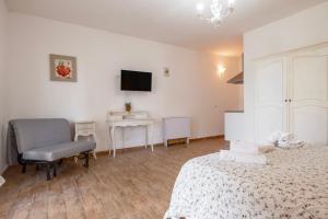a bedroom with two beds and a chair and a desk at Albergo Pietriccio Rosso in Manciano