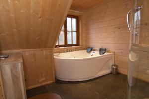 a large tub in a wooden bathroom with a window at Houten villa Albert in Den Ham +13 photos