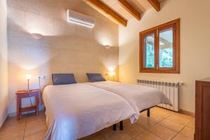 a bedroom with a large white bed with a window at Finca Biniali in Sencelles +17 photos