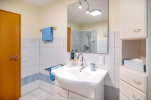 a white bathroom with a sink and a mirror at Easy Living in Tettnang +12 photos