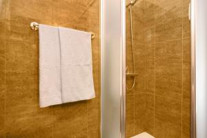 a bathroom with a shower with a white towel at Casa Orquidea T3 in Ponta do Sol +26 photos