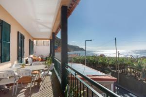 a balcony with a table and chairs and the ocean at Casa Orquidea T3 in Ponta do Sol