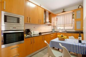 a kitchen with wooden cabinets and a table with bananas on it at Casa Orquidea T3 in Ponta do Sol