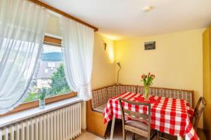 a dining room table with a red and white checkered table cloth at Bergblick in Forbach