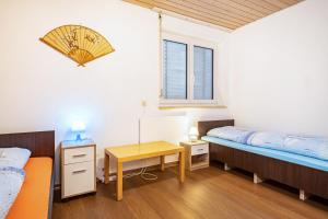 a bedroom with two beds and a table and a window at Nguyen und Le 2 in Neukirch