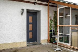 a black door on a white building with a window at Nguyen und Le 2 in Neukirch