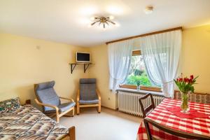 a bedroom with a bed and two chairs and a window at Bergblick in Forbach