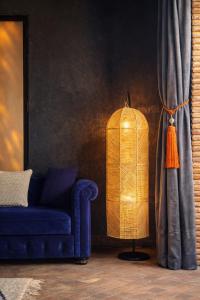 a living room with a blue couch and a lamp at Riad Jawad & Spa in Marrakesh +110 photos