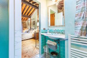 a bathroom with a sink and a mirror and a bed at Beb Pulcino Nero Scrofiano in Scrofiano