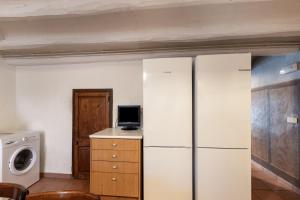 a kitchen with a refrigerator and a washer and dryer at Cal Contra in Gélida