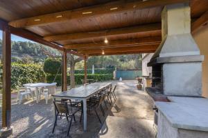a patio with a table and chairs and a fireplace at Cal Contra in Gélida