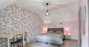 a bedroom with a bed and a table with chairs at Ô Pré des Fleurs in Amanlis