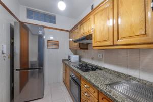 a kitchen with wooden cabinets and a stainless steel refrigerator at Piso Tazacorte in Puerto +14 photos