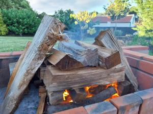a fire pit made out of wooden logs at De Baixo Da Ponte in Biscoitos