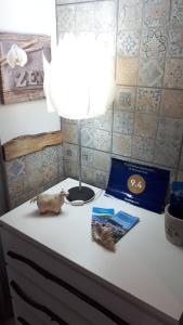 a lamp on a desk with a book and a pig toy at De Baixo Da Ponte in Biscoitos +22 photos
