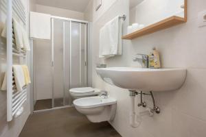 a white bathroom with a sink and a toilet at App Sonne Nr 16 in Lutago +6 photos
