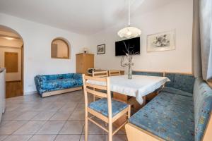 a living room with a table and a blue couch at App Sonne Nr 16 in Lutago