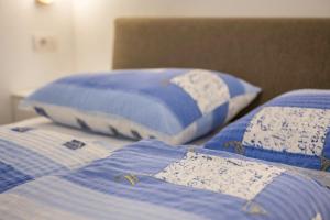 two beds with blue and white pillows on them at App Sonne Nr 16 in Lutago
