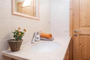 a bathroom with a sink and a mirror at Schildberghof Schlernblick in Kastelruth +30 photos