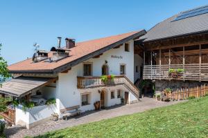 a large white building with a roof at Schildberghof Schlernblick in Kastelruth