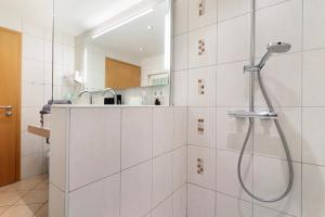 a white bathroom with a shower and a sink at Landeckhof in Oberwolfach +28 photos