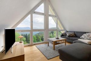a living room with a couch and a large window at Landeckhof in Oberwolfach
