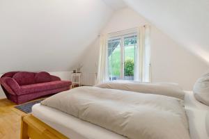 a bedroom with two beds and a red chair at Landeckhof in Oberwolfach