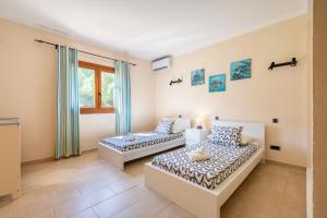 a room with two beds and a window at Finca Es Figueral in Campos +20 photos