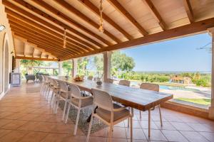 a dining room with a long table and chairs at Finca Es Figueral in Campos
