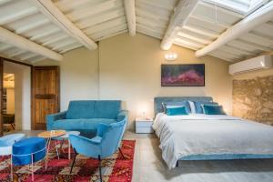 a bedroom with a bed and a couch and a chair at Brotes Appartamento Ciliegio in Sovicille +23 photos