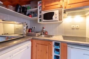a kitchen with a sink and a microwave at Gite Clarabide in Loudenvielle +12 photos