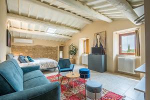 a living room with a blue couch and a bed at Brotes Appartamento Ciliegio in Sovicille