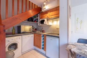 a small kitchen with a washer and dryer at Gite Clarabide in Loudenvielle