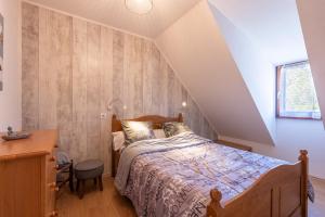 a bedroom with a bed and a desk and a window at Gite Clarabide in Loudenvielle
