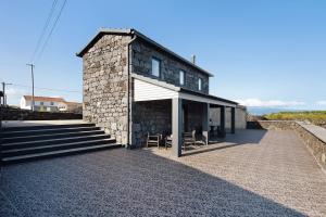 a small stone building with two chairs in front of it at Adega do Portinho Velho in Piedade