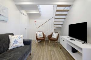 a living room with a couch and a flat screen tv at Adega do Portinho Velho in Piedade