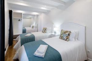 a hotel room with two beds and a mirror at Adega do Portinho Velho in Piedade