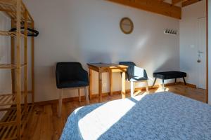 a bedroom with a desk and two chairs and a table at La Chastanha in Saint-Symphorien-de-Mahun