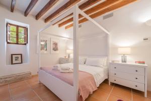 a bedroom with a white canopy bed and a dresser at Numero Uno in Búger +18 photos