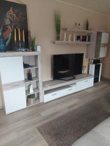 a living room with a tv in a white entertainment center at Tapas restaurante 1 in Viersen