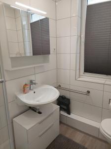 a white bathroom with a sink and a mirror at Tapas restaurante 1 in Viersen +18 photos