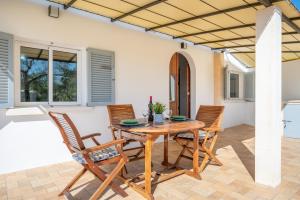 a dining room with a wooden table and chairs at Ses Oliveres in Pollença